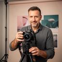 Javier Martín, profesor de fotografía, ajustando una cámara en un pequeño estudio de retrato